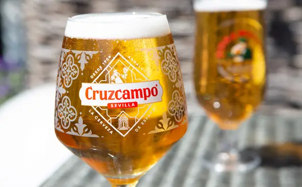 Pint of Birra Moretti and Cruzcampo beer on terrace table in the sunshine