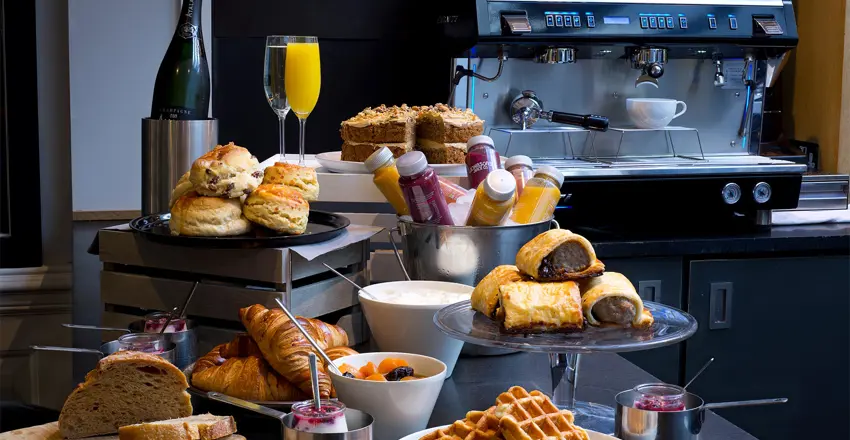 Waffles, croissants, scones, cakes and sausage roll display on the bar at The Crown at Woodbridge